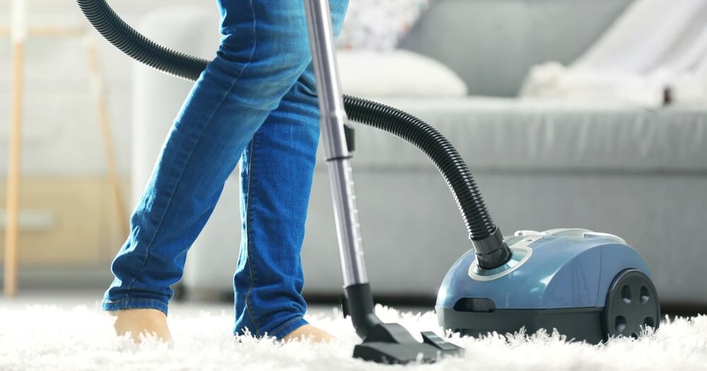 Woman cleaning the carpet with vacuum cleaner - Vacuum Specialists
