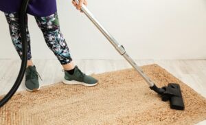 Close up woman vacuum cleaning carpet - Vacuum Specialists