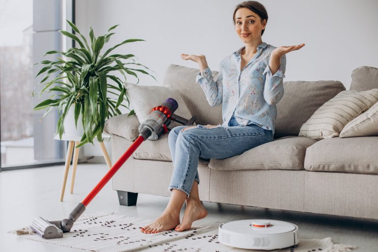 Woman sitting on sofa and choosing vacuum cleaner